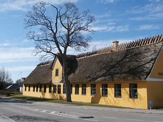 Den gamle skole set fra vejen. Facaden er gulpudset