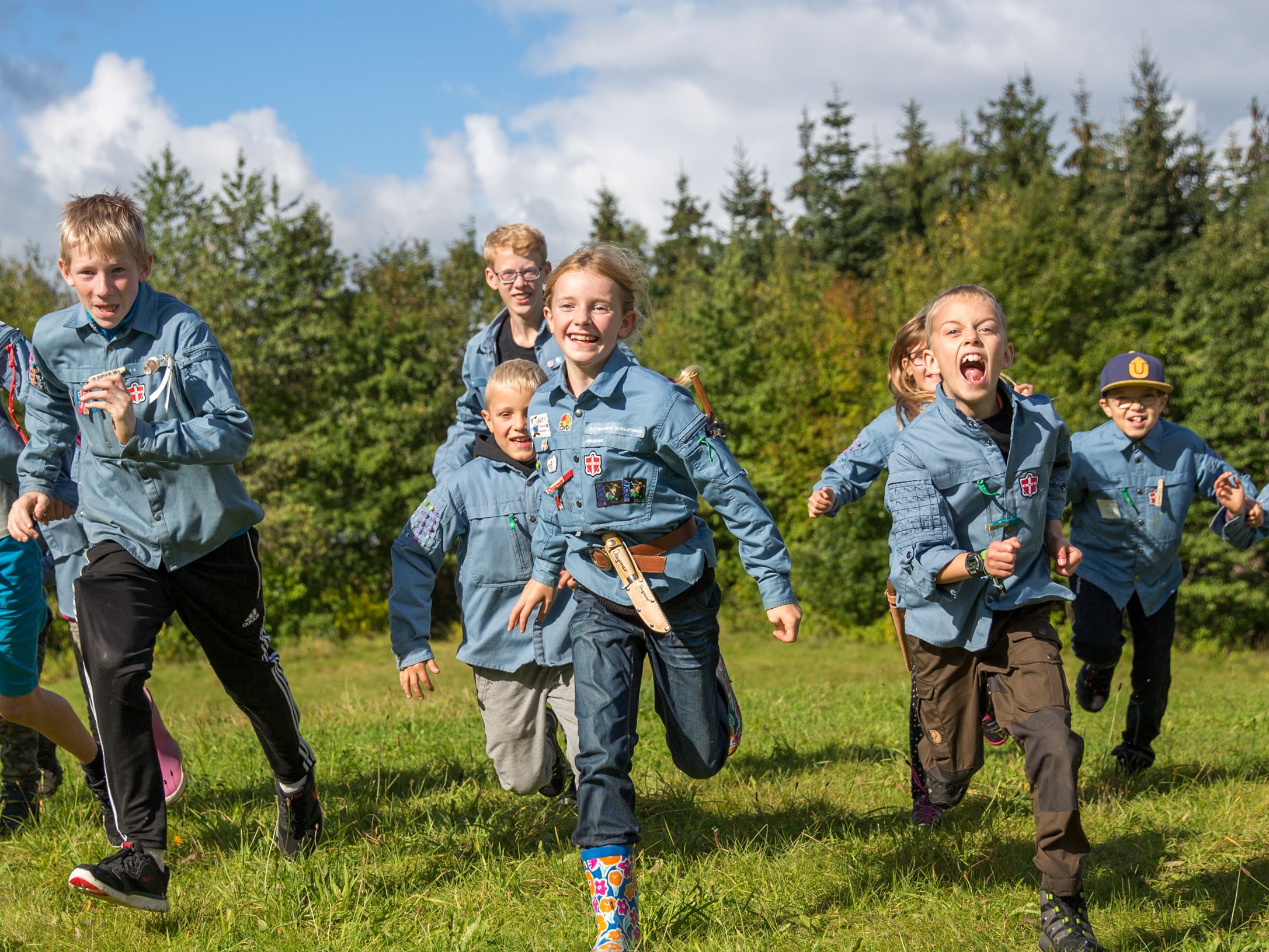FDF'erer – stor og små børn – løber på en mark