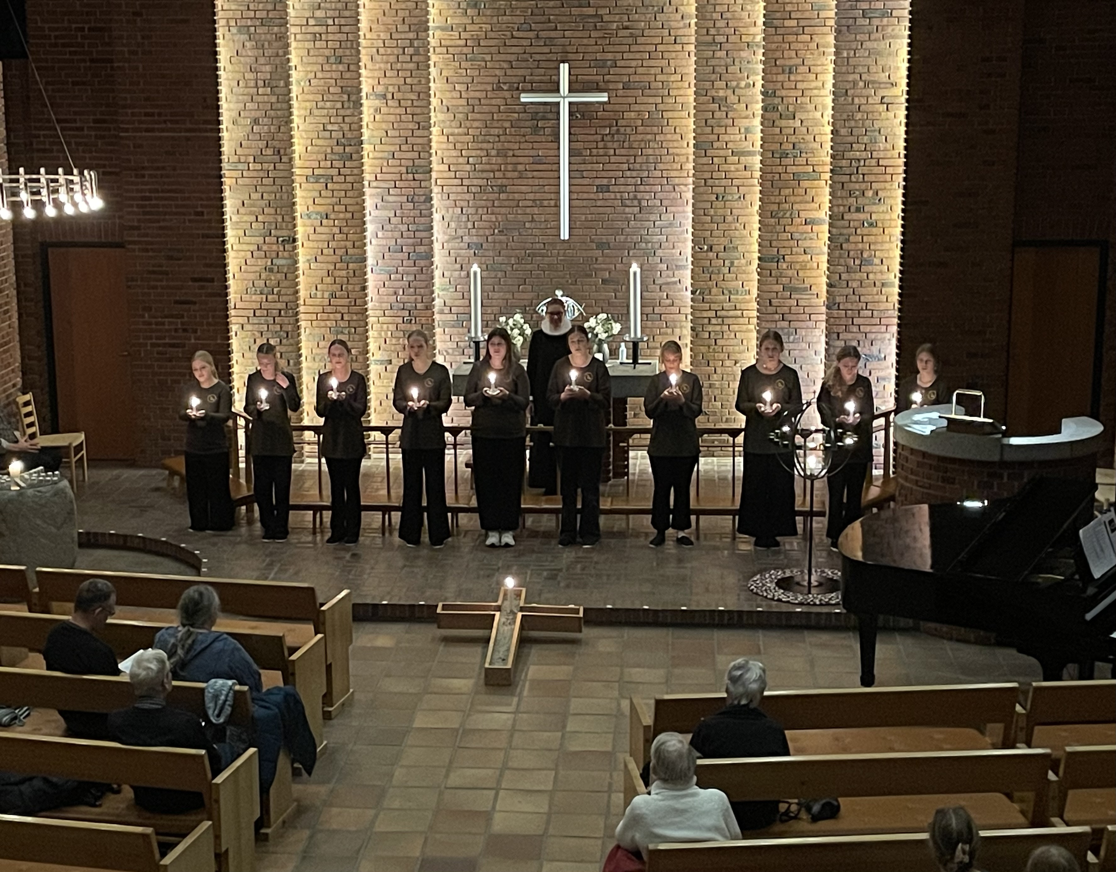 Pigrkoret foran alteret i Hundige Kirke. De holder alle et tændt lys i hånden.
